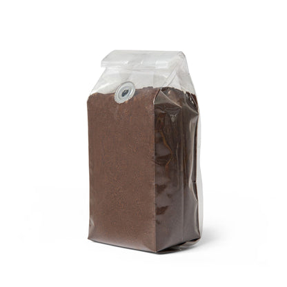 Clear plastic bag with brown sand-like material on a white background